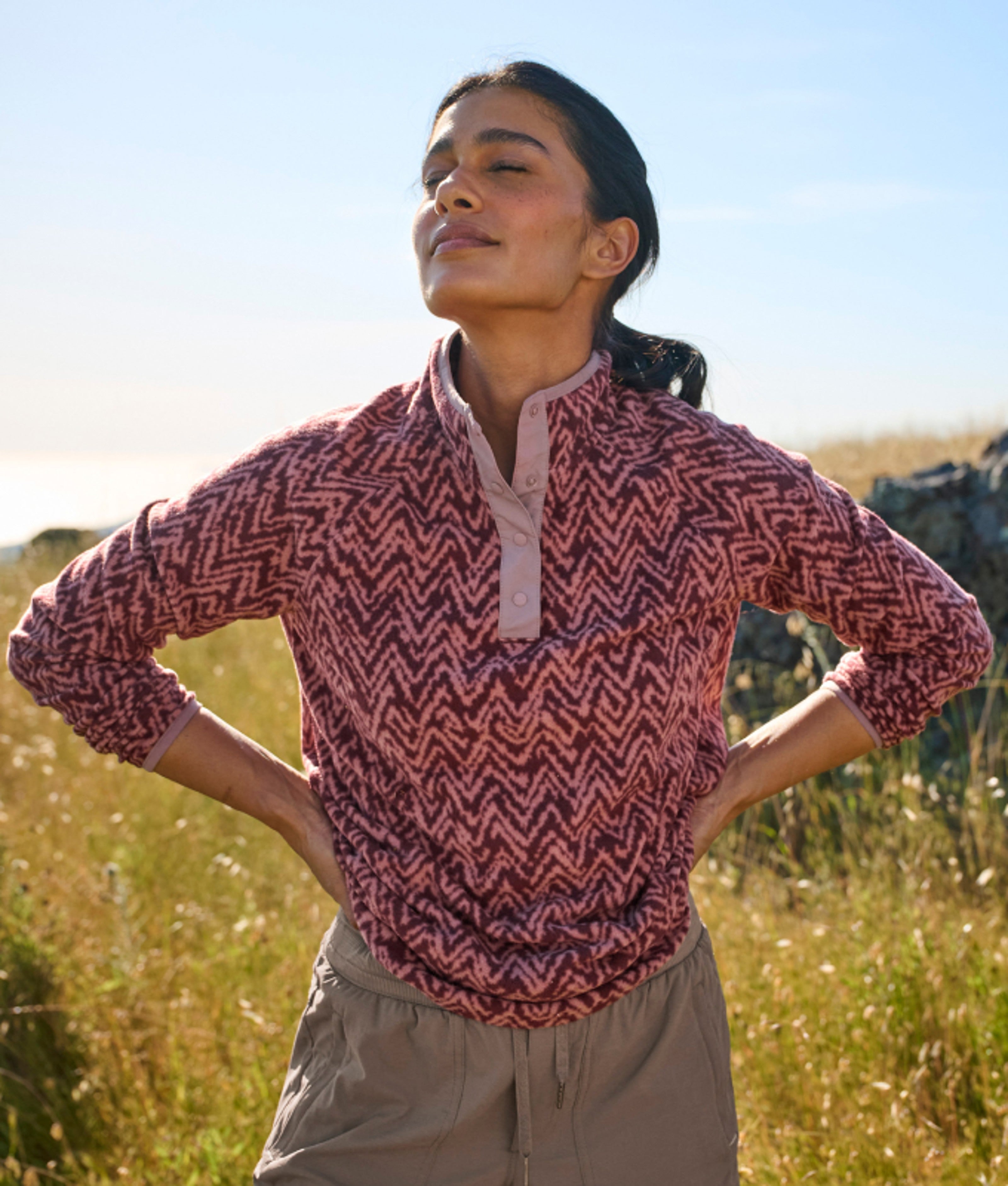 Person outdoors wearing a patterned quarter-zip fleece pullover.