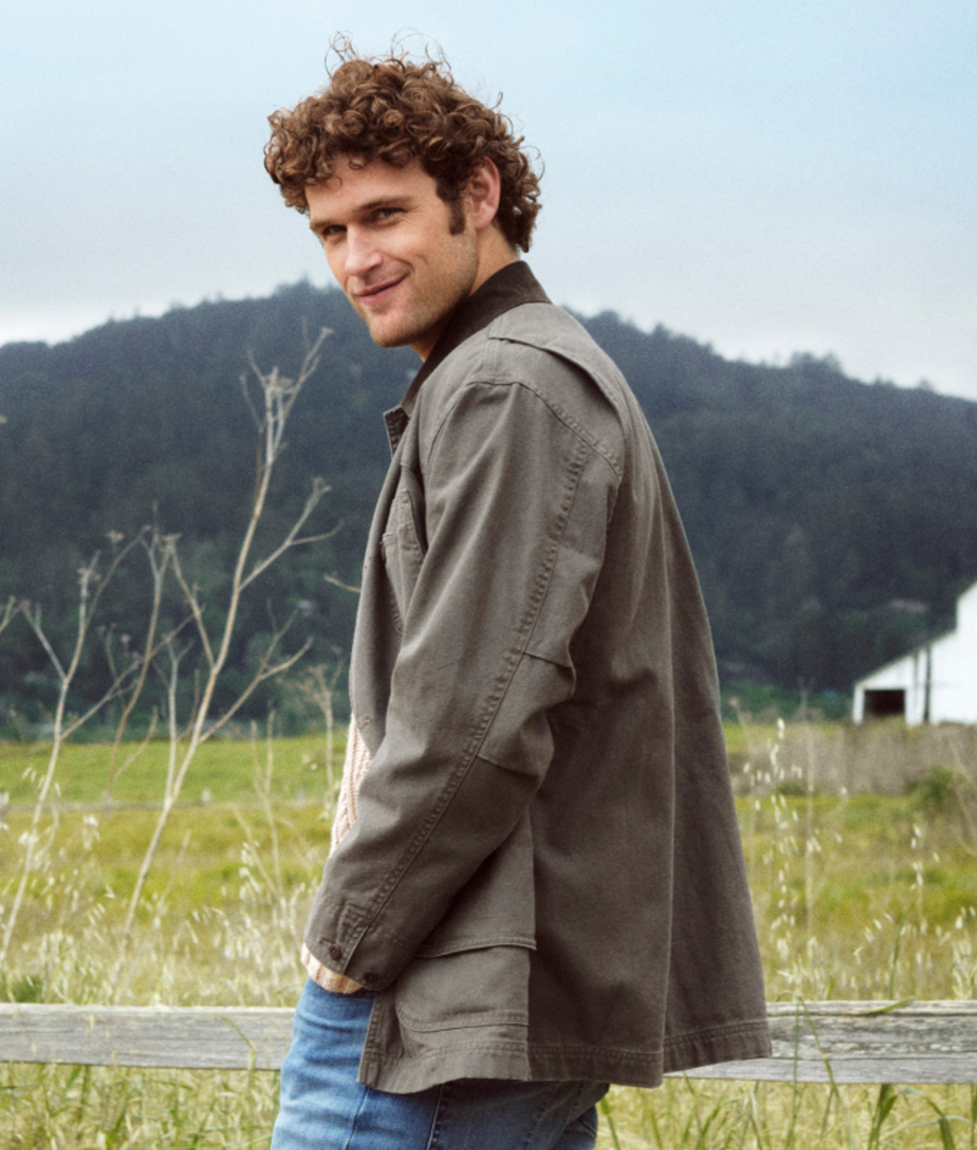Person wearing an olive field jacket outdoors.