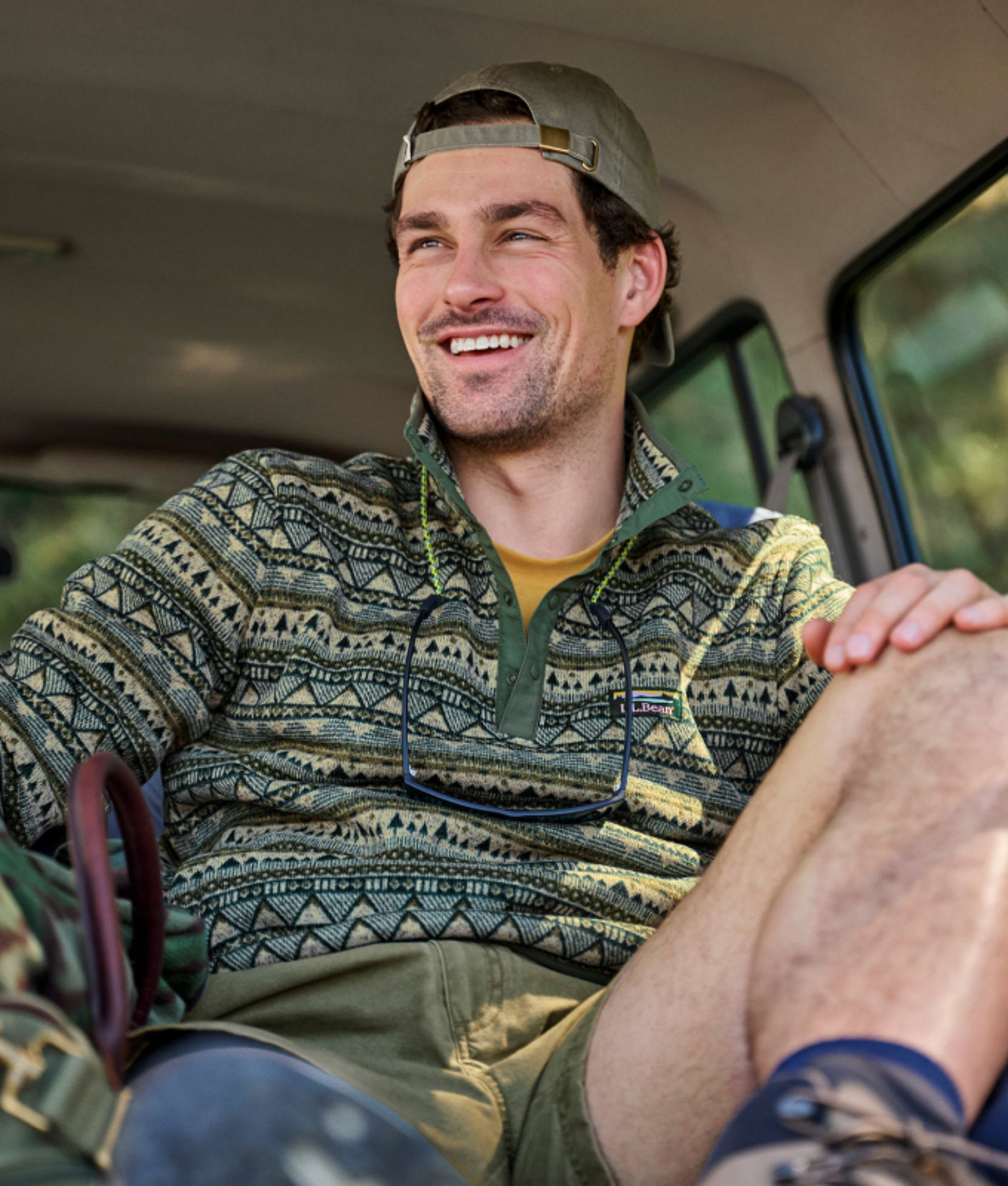 Person sitting in a vehicle wearing a patterned fleece pullover.